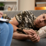 male struggling with ptsd laying on a couch talking to doctor