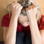 Woman frustrated with head in hands, exhibiting anger management issues