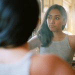 Woman in mirror remembering childhood trauma