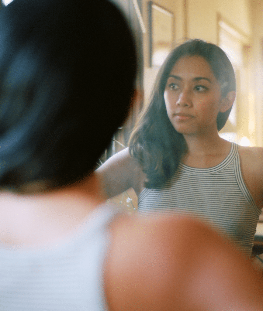 Woman in mirror remembering childhood trauma