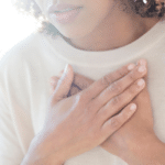 woman clutching her chest with hands overlapped, wondering, "What is valium?" when used for mental health issues like depression and anxiety