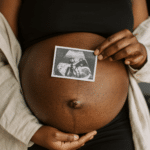 woman with sonogram over pregnant belly, preparing for the possibility of postpartum rage