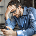 man looking at phone, waiting on girlfriend to text him, dealing with abandonment and attachment issues