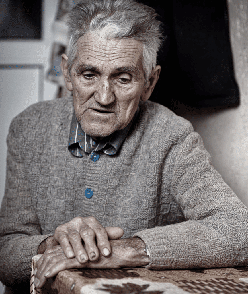 man considering the causes and risk factors of dissociative identity disorder looking down at the table