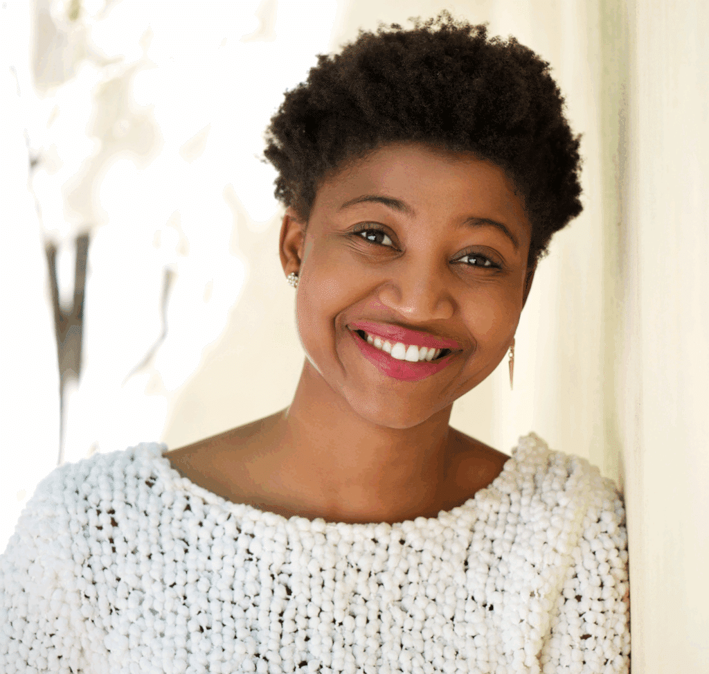 woman of color smiling after getting treatment for the risk factors of Dissociative Identity Disorder