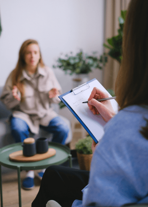 woman in an Acceptance and Commitment Therapy session and therapist with a clipboard