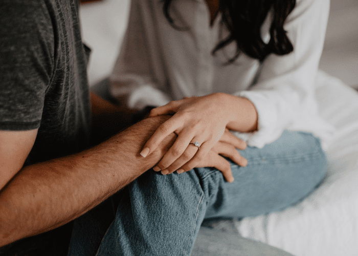 man and woman holding hands after psychodynamic therapy, woman with engagement ring on