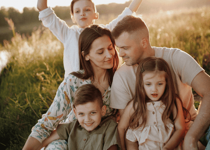 Family with woman, man, two sons and a daughter, all hugging after husband has got treatment for narcissistic personality disorder