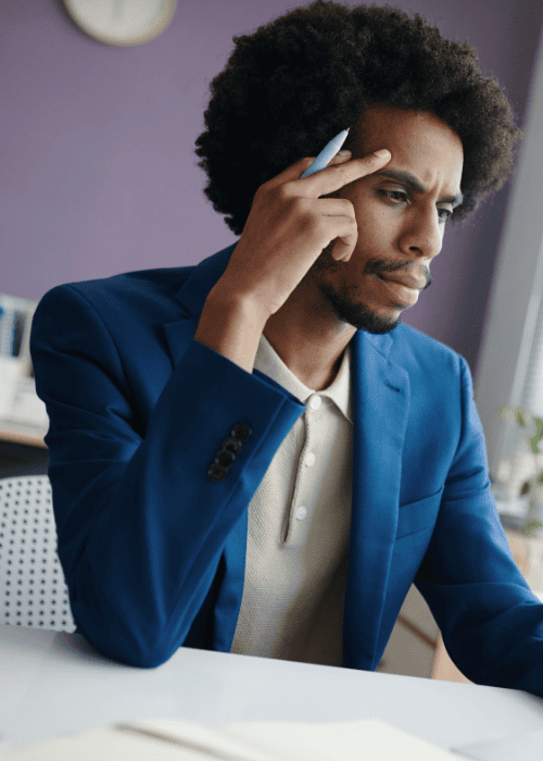 man sitting at desk frowning experiencing memory problems & brain fog in adults