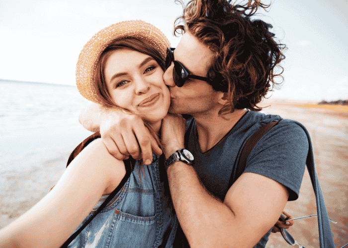 couple hugging happily on the beach after receiving support for conflict avoidance in adults