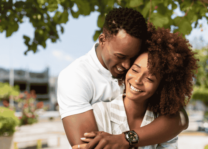 couple outside with trees in background smiling after treatment for fear of abandonment in adults
