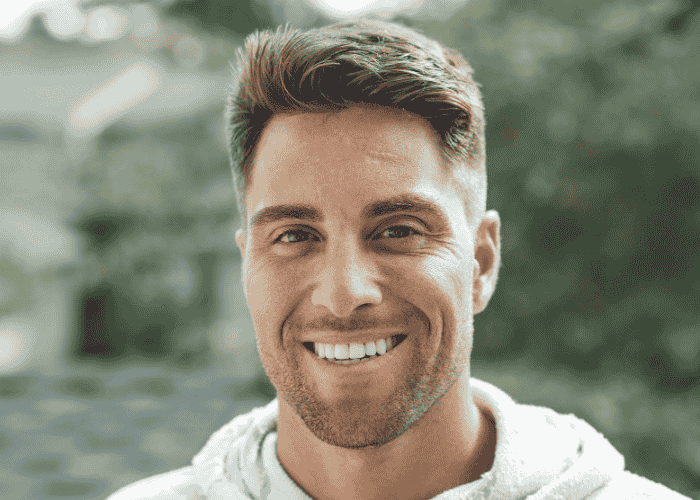 man smiling at the camera while recovering after self-destructive behavior in adults