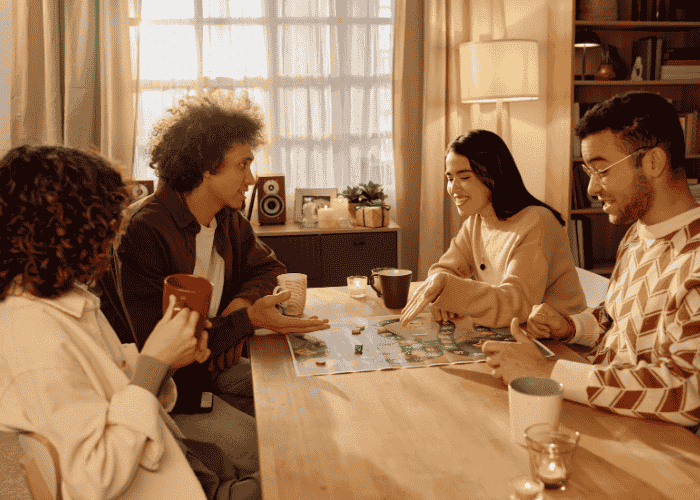 group of friends together at the table playing a board game after woman has recovered from social withdrawal in adults