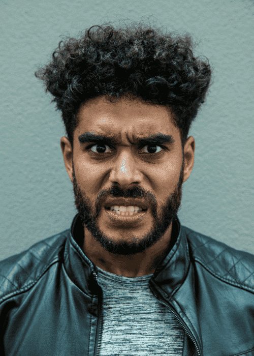 Angry man looking at the camera with an angry facial expression due to emotional overreactions in adults