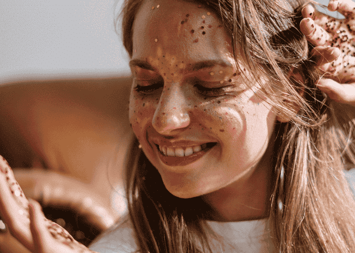 Woman smiling with glitter on her face after getting treatment for skin picking disorder