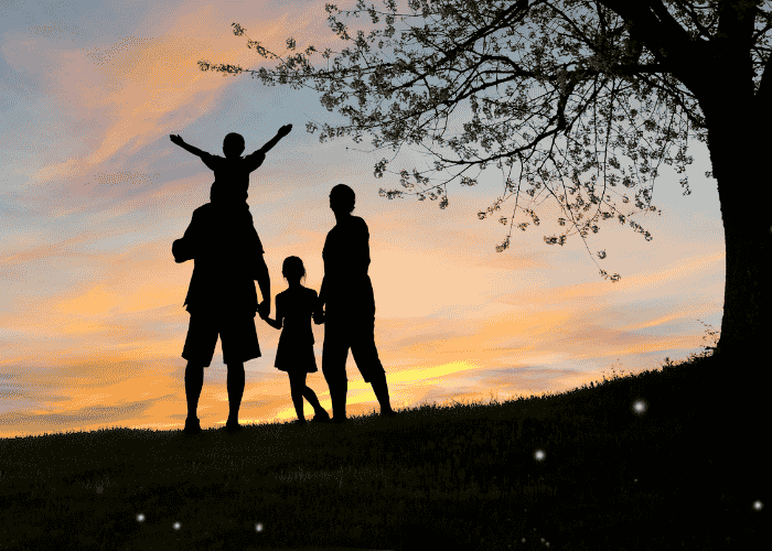 Family silhouttes stood in front of a sunset after receiving treatment for heart palpitations & anxiety in adults