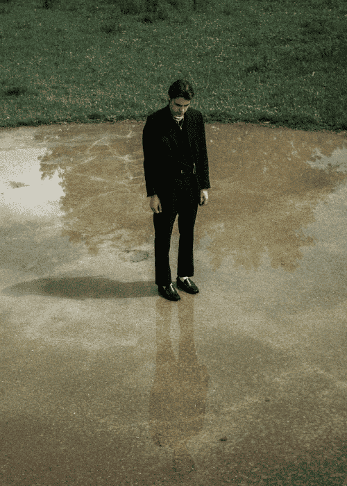 Man standing on his own in the rain unsure what to do due to indecisiveness in adults