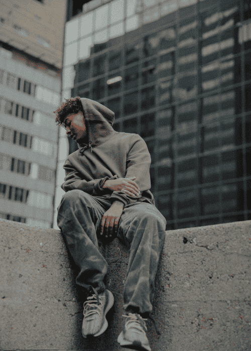 Man sitting on top of a building looking down experiencing intrusive thoughts in adults