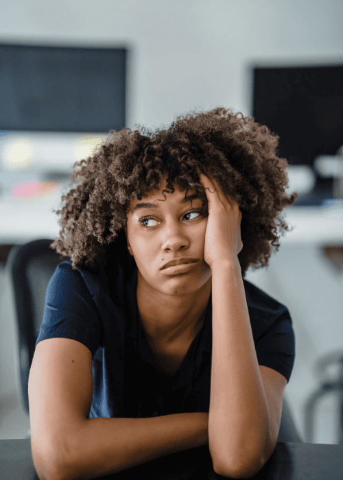 Woman sitting at the table looking fed up due to restlessness in adults