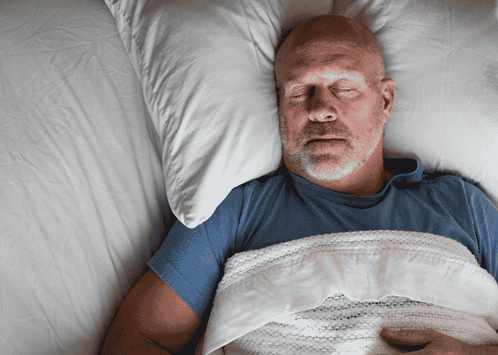 man in bed sleeping soundly after receiving treatment for sleep problems