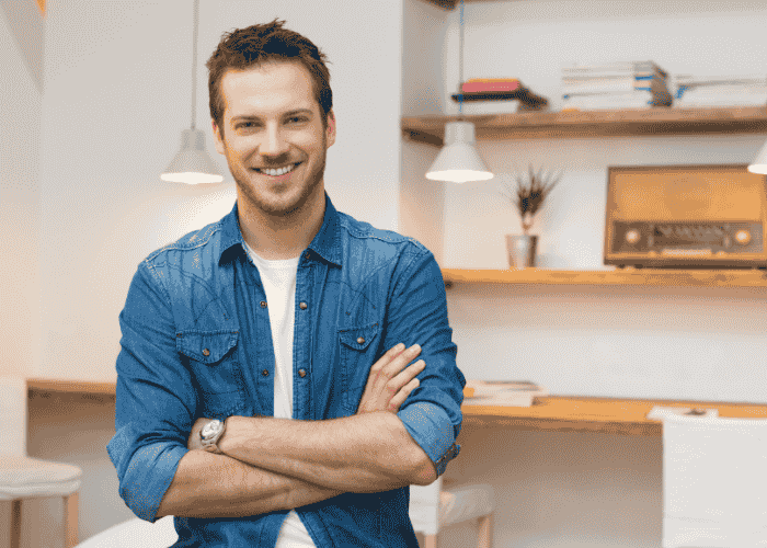 Man smiling in home office after successful treatment for mood swings.