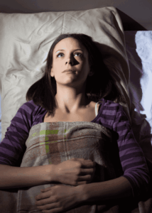 women lying awake in bed wondering about sleep problems and solutions