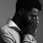 man holding hands up to mouth due to experiencing restlessness & anxiety in adults