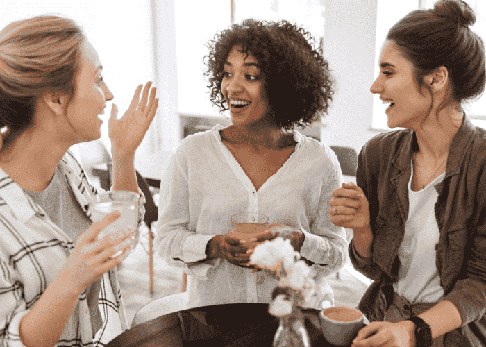 woman having coffee with friends smiling after treatment for hopelessness in adults