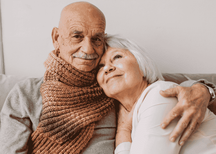 man with arm around wife sitting on sofa smiling after treatment for processing difficulties