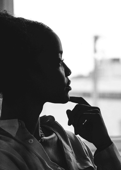 Woman looking thoughtfully out of the window, struggling with compulsive mental checking in adults