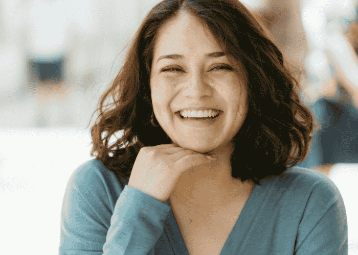 Woman smiling at the camera after receiving treatment for compulsive mental checking in adults