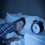Woman awake in the middle of the night due to sleep disruption in adults