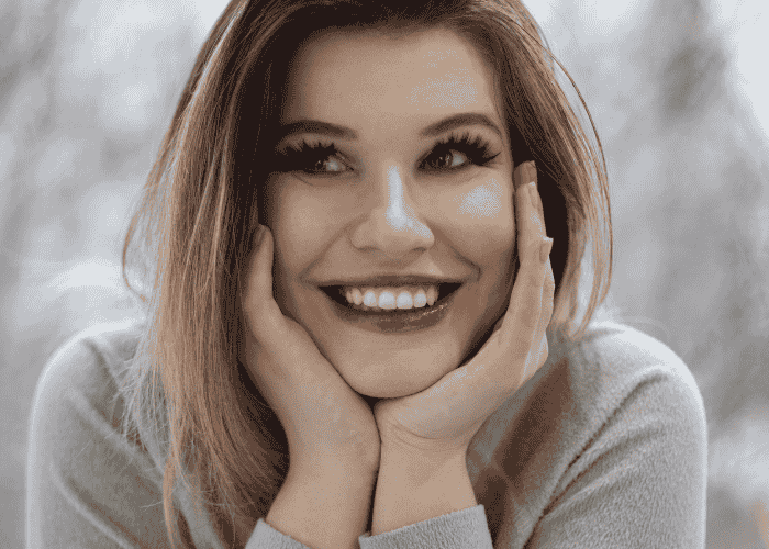 Woman looking happy at herself due to overcoming excessive self-criticism in adults