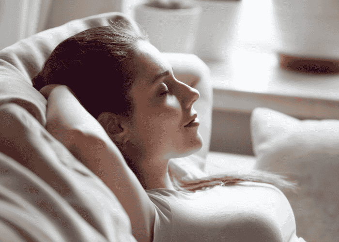 Woman laying down with a calm expression after getting treatment for hypomania symptoms in adults