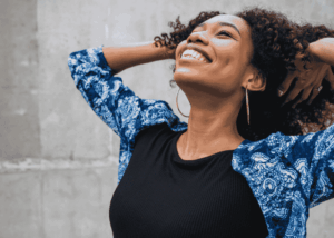Woman smiling looking up to the sky with a happy and relieved expression after receiving treatment for paresthesia related to stress in adults