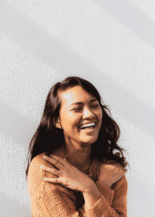 Woman smiling and hugging herself after getting treatment for interruptions in thought processes in adults