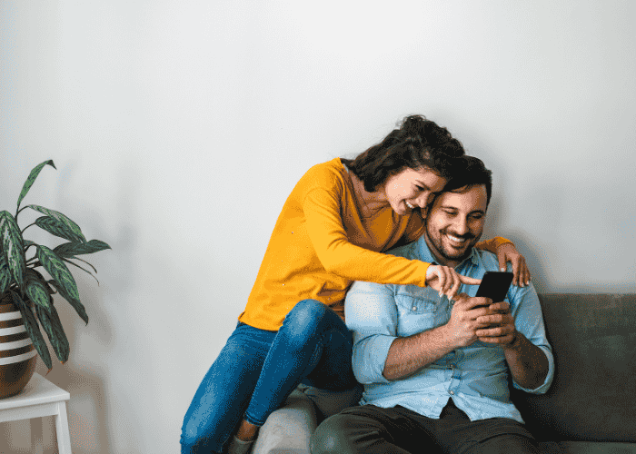 Happy couple on the couch together after getting treatment for fear of rejection in adults