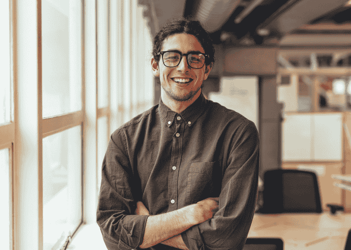 Man smiling at the camera after receiving treatment for overcompensating in adult relationships