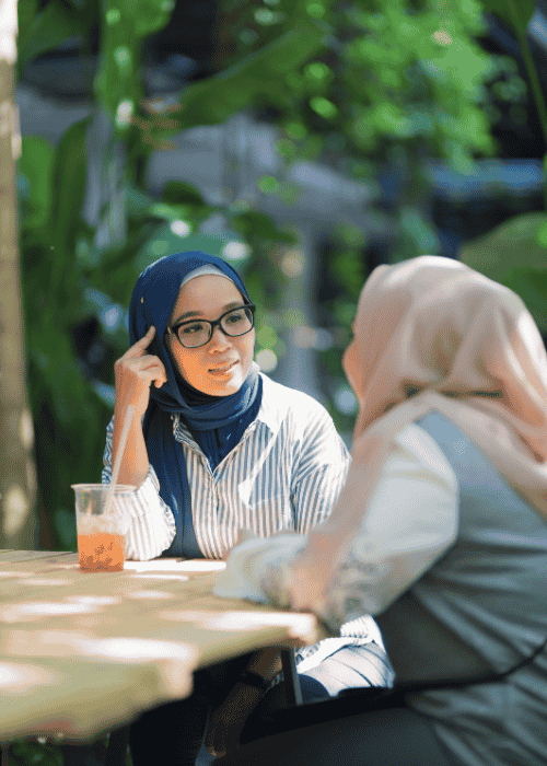 Two muslim women speaking to one another, experiencing oversharing in adults