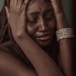 Woman in distress with her hands clutching her head due to paranoid thoughts in adults