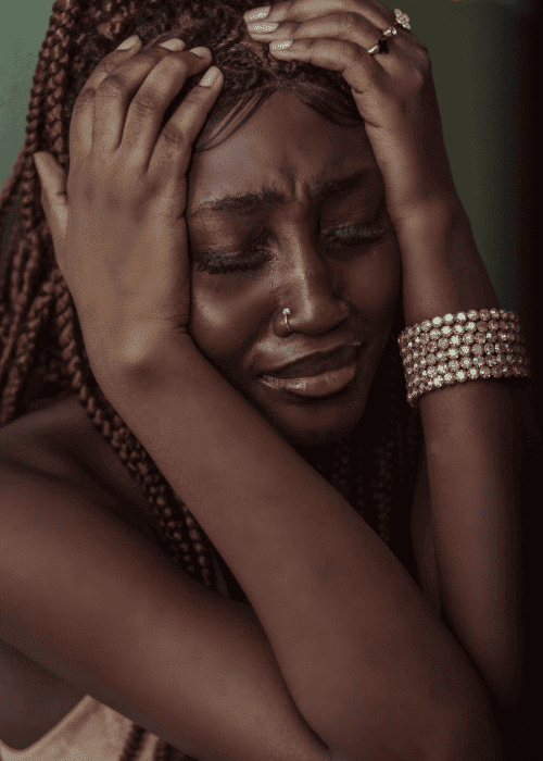 Woman in distress with her hands clutching her head due to paranoid thoughts in adults