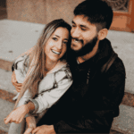 Couple hugging and smiling due to treatment for over-apologizing in adults