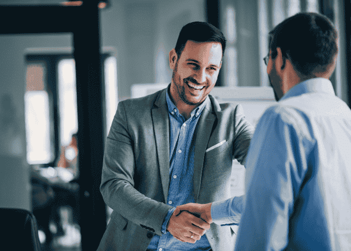 Man shaking hands with his boss and smiling after treatment for distrust of authority in adults