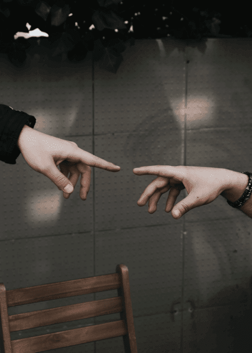 Two hands almost touching each other representing refusal to ask for help in adulthood