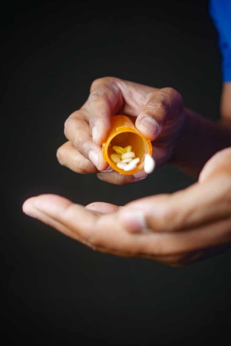 hands holding a pill bottle with small white round pills, ativan for anxiety