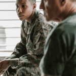 Female veteran sitting in meeting worrying about TriWest coverage for mental health treatment