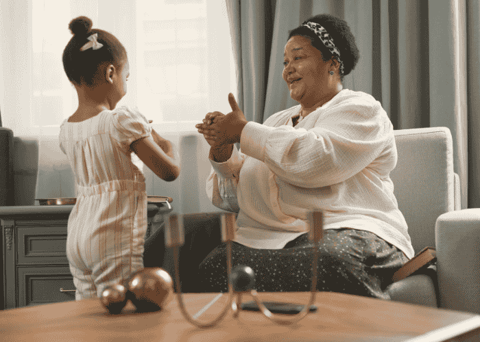 Woman with small sitting on sofa smiling at young daughter after seeking support with Anthem insurance coverage