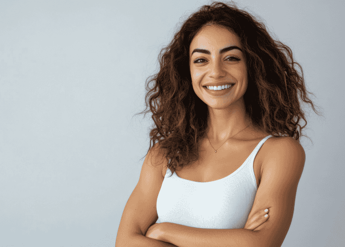 woman standing arms crossed smiling after seeking support with ComPsych mental health coverage