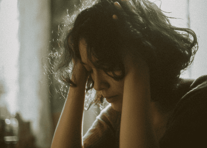 Woman with her head in her heands struggling with her mental health due to Virginia mental health provider shortages