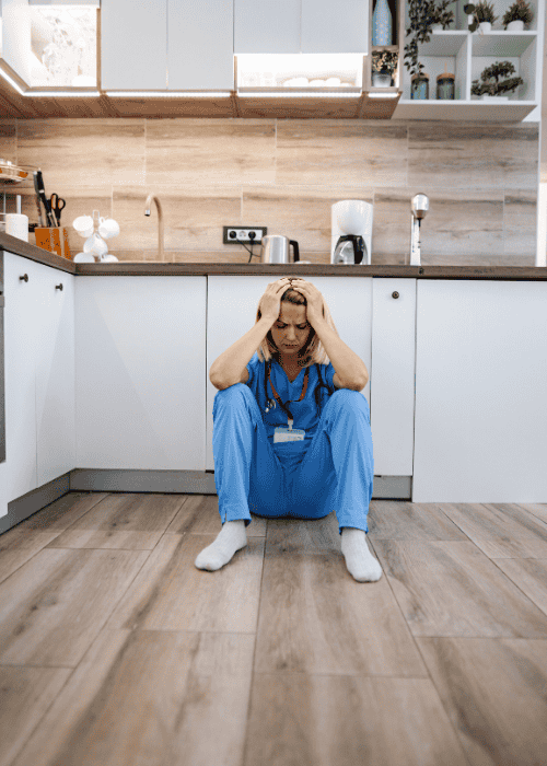 Woman sitting on the floor distressed wondering how cognitive distortions lead to burnout